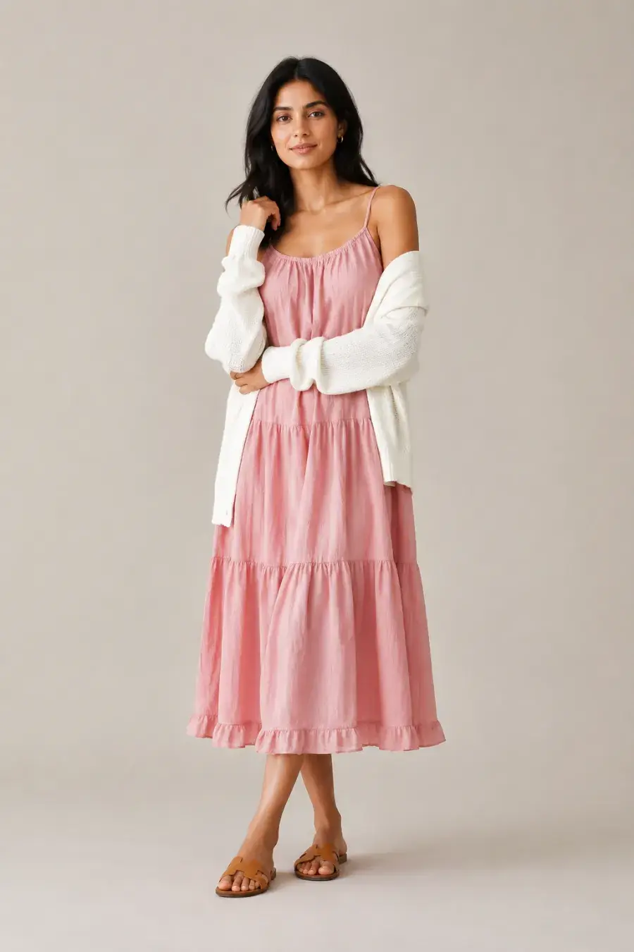 An adult South Asian woman wearing a blush-pink cotton sundress with thin straps, a draped ivory cardigan, and flat tan sandals, soft daytime pose, full body, entire figure from head to feet in frame, centered with headroom