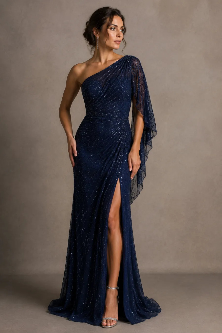 A woman in her thirties wearing a floor-length black-tie gala gown in deep sapphire blue with subtle beading, standing in a softly lit ballroom, full body